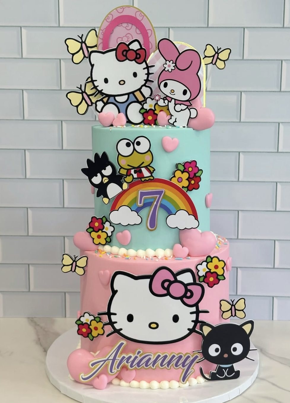 Two-tier pastel Hello Kitty and Sanrio character birthday cake for a 7th birthday